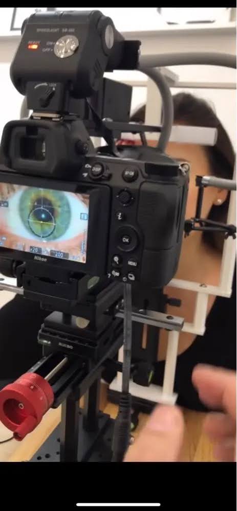 Iris image on the camera screen, with an earlier LS18 and a red micrometer knob beneath the camera